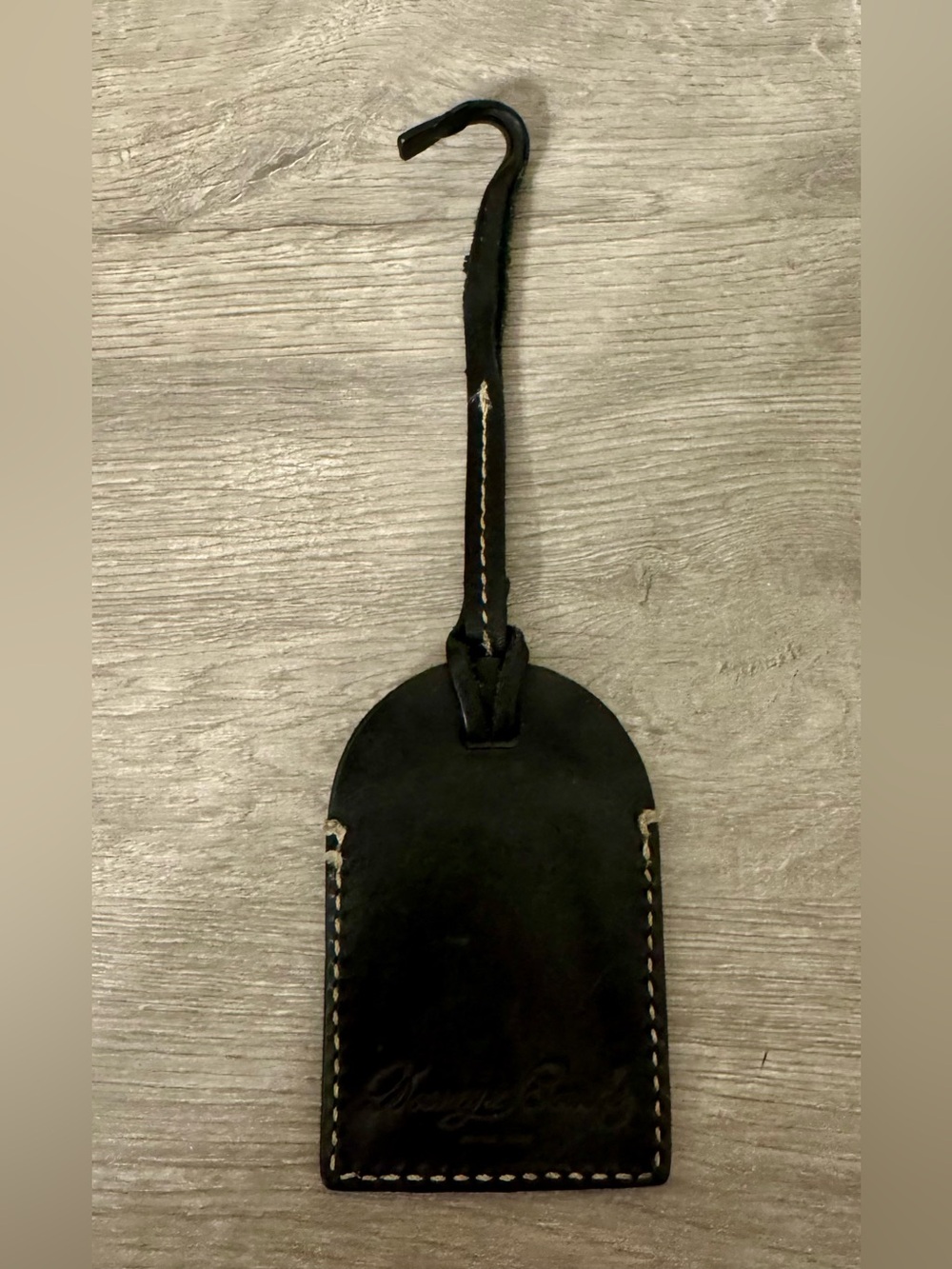 Dooney & Bourke . This authentic Dooney & Bourke leather luggage tag features th